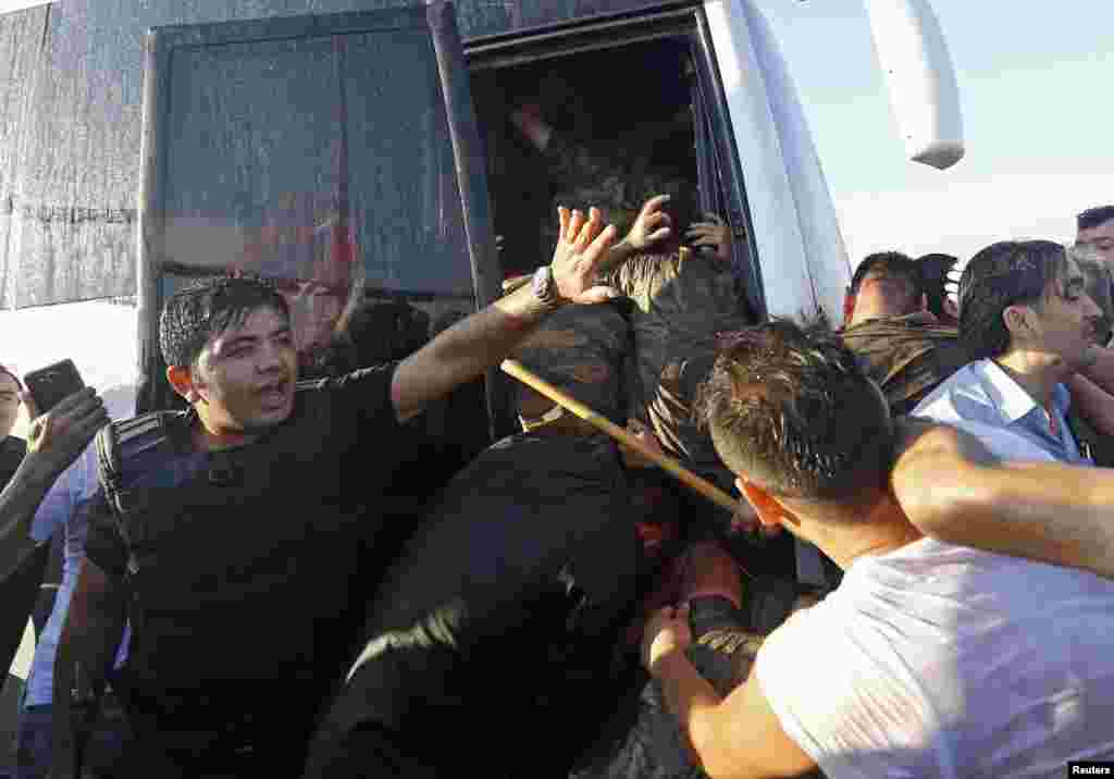 A policeman protects soldiers from a mob after troops involved in the coup surrendered on the Bosphorus bridge in Istanbul on July 16.