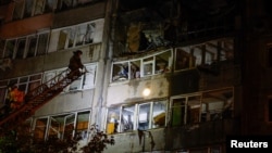 Firefighters work outside a damaged multistory residential building in the occupied city of Makiyivka on September 8, following what local Russian-installed authorities called a Ukrainian military strike. 