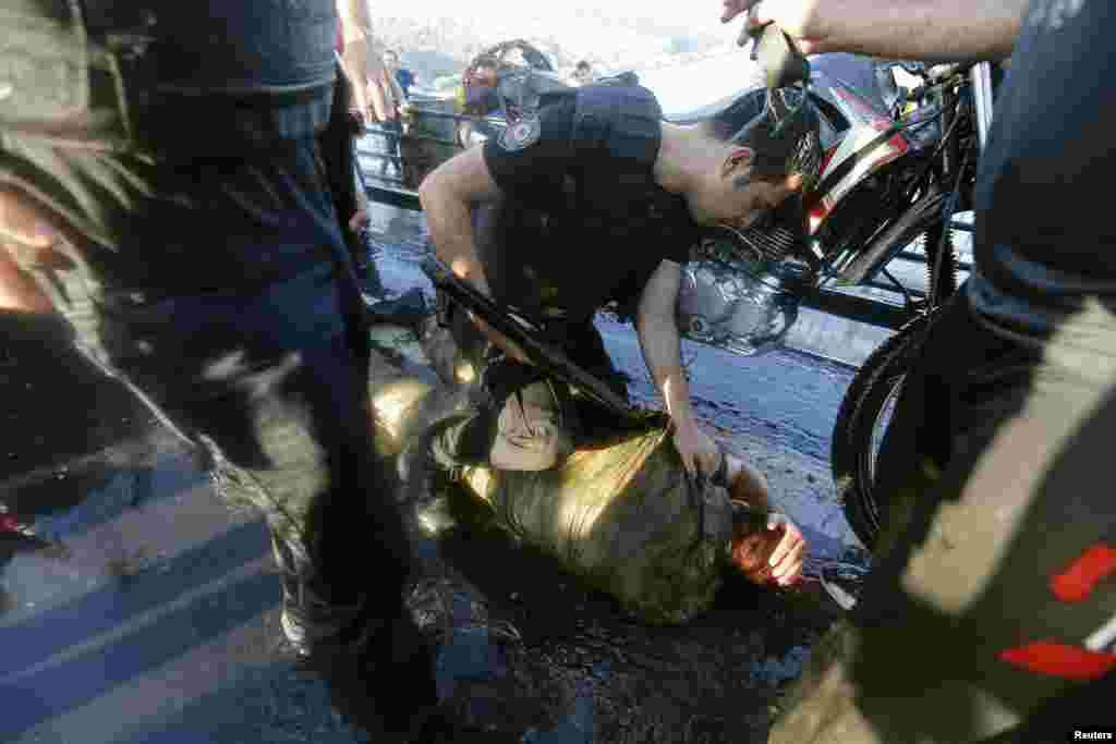 A policeman checks the condition of a soldier beaten by a mob after troops involved in the coup surrendered on the Bosphorus bridge in Istanbul on July 16.