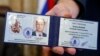 Керівник виборчкому Валентин Горбунов демонструє посвідчення кандидата на мера Москви Олексія Навального, 17 липня 2013 року