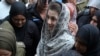 Police officers escort Maryam Nawaz as she appears at a court in Lahore in August.