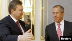 Russian Foreign Minister Sergei Lavrov (right) has urged the opposition to fulfill its part in a deal concluded with Ukrainian President Viktor Yanukovych (left) on February 21.