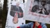 A demonstrator holds signs during a protest outside the US Embassy in Kyiv on March 15. 