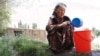 Kyrgyzstan Batken Old lady filling her bucket with water from the stream video grab October 27, 2016