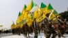 Men from the Iranian-backed group Kataib Hizballah wave party flags as they walk along a street painted in the colours of the Israeli flag during a parade marking the annual Quds Day, or Jerusalem Day, in Baghdad in 2014.