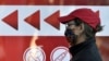 A woman wearing a face mask stands in line outside a pharmacy in Almaty, Kazakhstan.